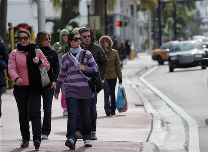 Tourists walk along Ocean Drive in South Beach Miami, Florida