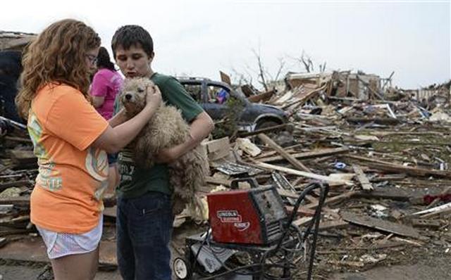 Abby Madi and Peterson Zatterlee comforts Zaterlee's dog Rippy, after a tornado struck Moore, Oklahoma