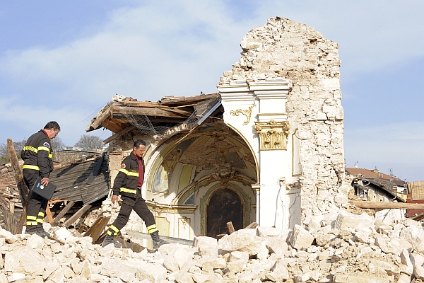 Fire department rescue personnel walk through the rubble of Saint Gregorio Magno church in Saint Gregorio village near L'Aquila April 12, 2009. Thousands of people made homeless by Italy's deadliest earthquake in 30 years celebrated a sombre Easter on Sunday, huddling for mass at makeshift chapels set up in tent cities and emergency shelters. REUTERS/Alessandro Bianchi (ITALY DISASTER RELIGION)